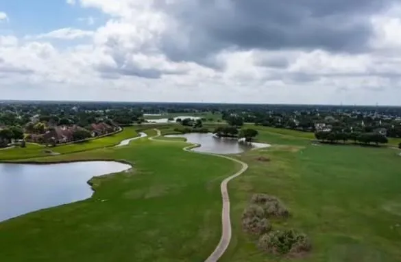 a view of a large building with a lot of windows and wooden fence