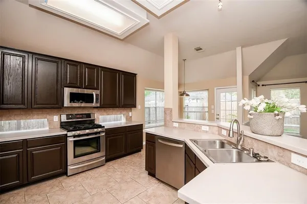 a kitchen with stainless steel appliances wooden cabinets a sink and a stove