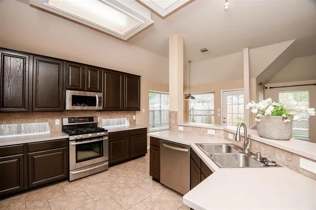a kitchen with stainless steel appliances wooden cabinets a sink and a stove