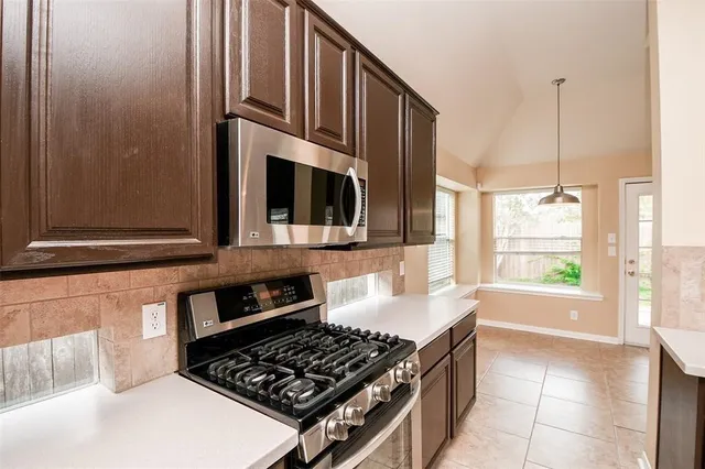 a kitchen with stainless steel appliances granite countertop a stove and a microwave