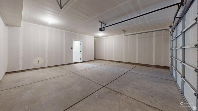 777 Pheasantbrook Drive, Unit 2B Centerville, UT 84014 - Photo 39 of 42 Spacious garage with exposed concrete flooring, unfinished drywall, and a white interior door