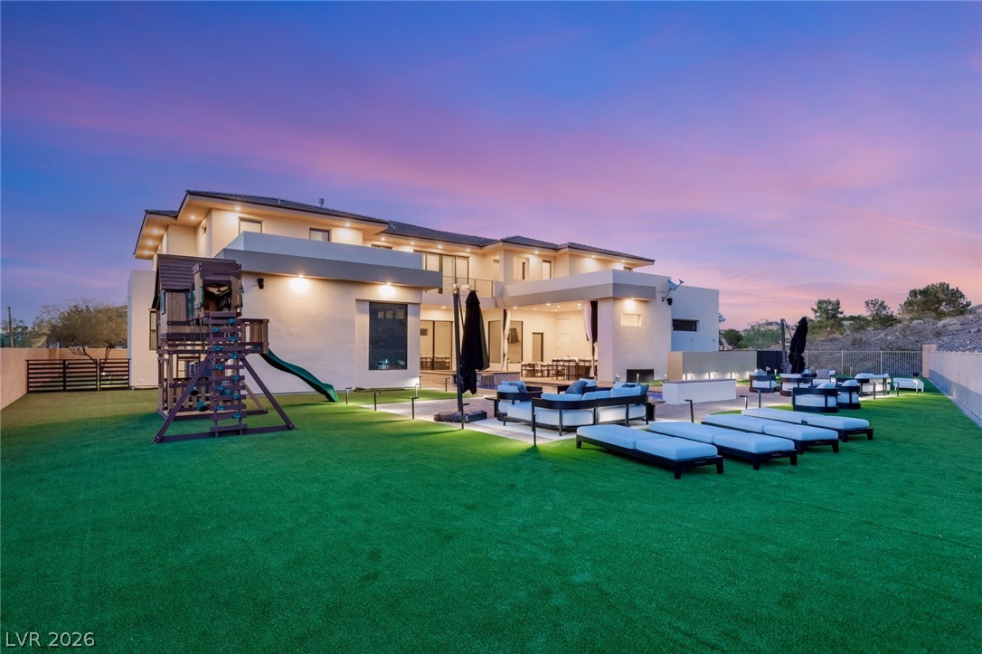 5 Crystal Tree Pass Henderson, NV 89052 - Photo 53 of 67 An inviting backyard oasis offers multiple lounge areas and a play structure for endless entertainment.