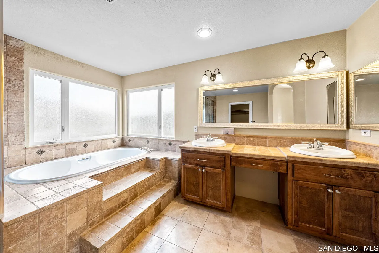 9648 Eucalyptus Street Spring Valley, CA 91977 - Photo 30 of 39 a spacious bathroom with a tub sink and mirror