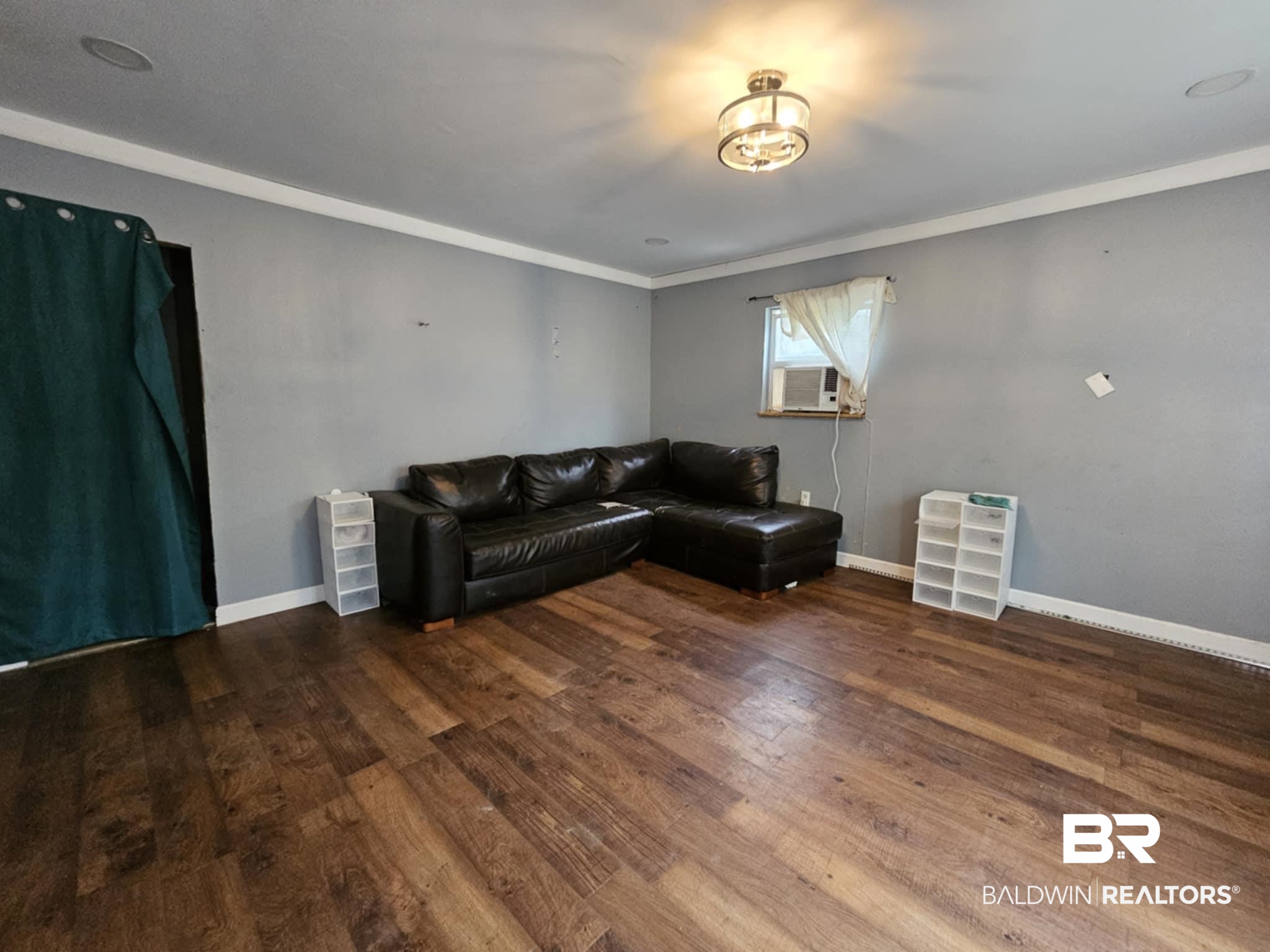 Living area featuring ornamental molding, baseboards, and wood finished floors