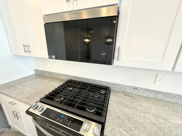 a kitchen with white cabinets and black appliances