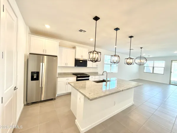 a kitchen with stainless steel appliances granite countertop a sink a stove and a refrigerator