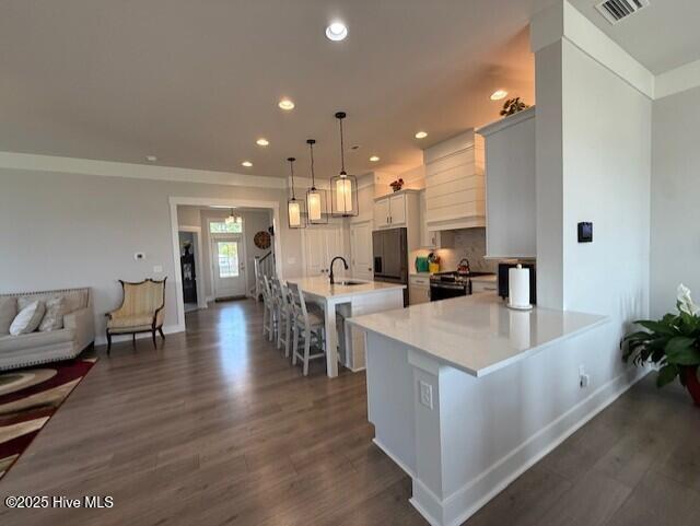203 Farmstead Loop Moyock, NC 27958 - Photo 11 of 75 OPEN KITCHEN WITH QUARTZ COUNTER TOPS, SOFT CLOSE CABINETRY, GAS RANGE, MICROWAVE, DISHWASHER AND 2ND WALL OVEN, OVER/UNDER CABINTRY LIGHTING, DEEP SINK IN ISLAND, THIS IS THE CENTRAL POINT OF THE DOWNSTAIRS AREA.