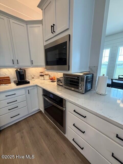 203 Farmstead Loop Moyock, NC 27958 - Photo 14 of 75 OPEN KITCHEN WITH QUARTZ COUNTER TOPS, SOFT CLOSE CABINETRY, GAS RANGE, MICROWAVE, DISHWASHER AND 2ND WALL OVEN, OVER/UNDER CABINTRY LIGHTING, DEEP SINK IN ISLAND, THIS IS THE CENTRAL POINT OF THE DOWNSTAIRS AREA.