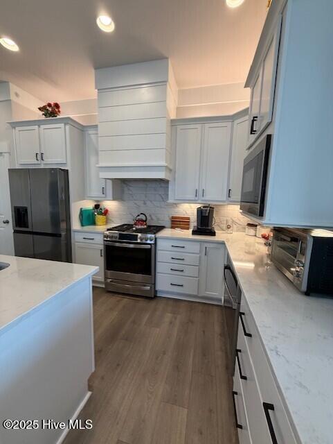 203 Farmstead Loop Moyock, NC 27958 - Photo 15 of 75 OPEN KITCHEN WITH QUARTZ COUNTER TOPS, SOFT CLOSE CABINETRY, GAS RANGE, MICROWAVE, DISHWASHER AND 2ND WALL OVEN, OVER/UNDER CABINTRY LIGHTING, DEEP SINK IN ISLAND, THIS IS THE CENTRAL POINT OF THE DOWNSTAIRS AREA.