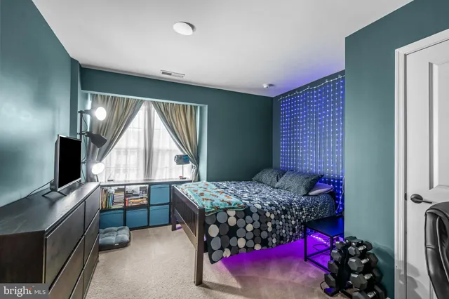 a bedroom with a bed and lamp with wooden floor