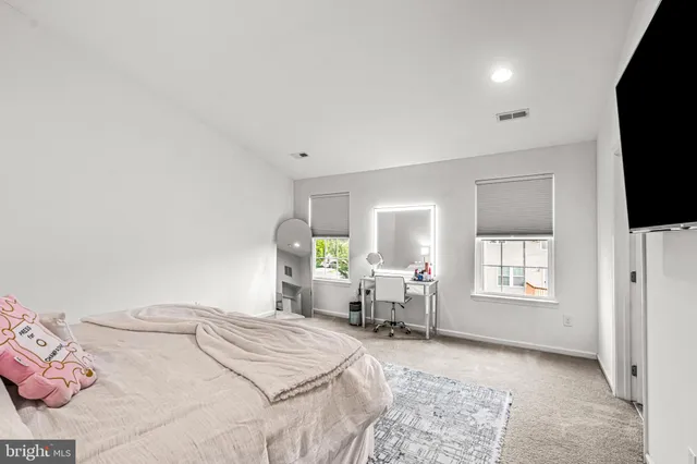a bedroom with a bed and lamp with wooden floor