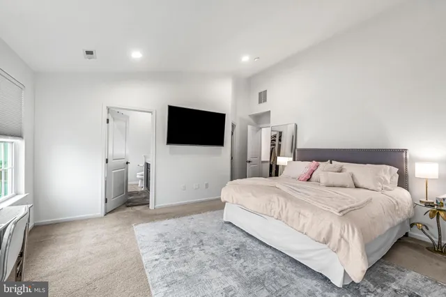 a large bedroom with a bed a desk and chair