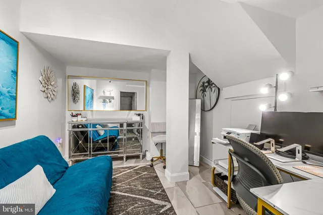 a living room with a couch and a view of kitchen