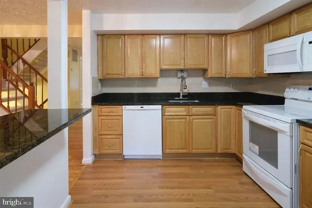 a kitchen with granite countertop appliances cabinets and a counter top space