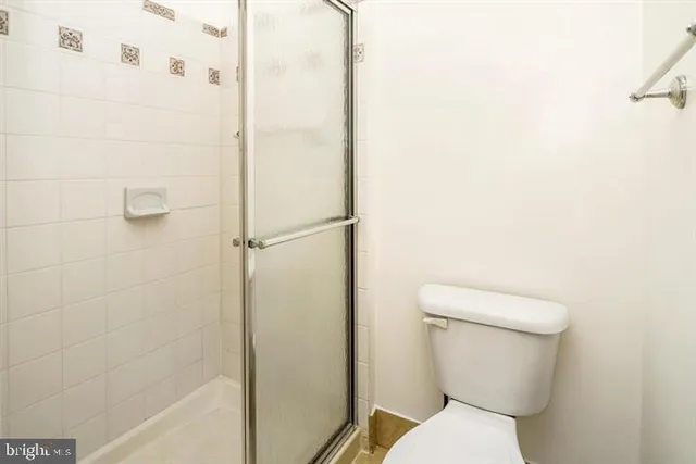a view of bathroom with a toilet a sink and mirror