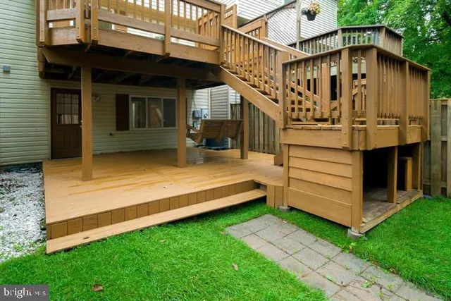 a view of a patio with wooden floor and roof with a garden