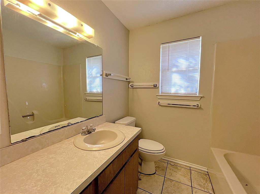 1106 Curtis Drive, Unit A Weatherford, TX 76086 - Photo 11 of 13 a bathroom with a sink toilet and a mirror