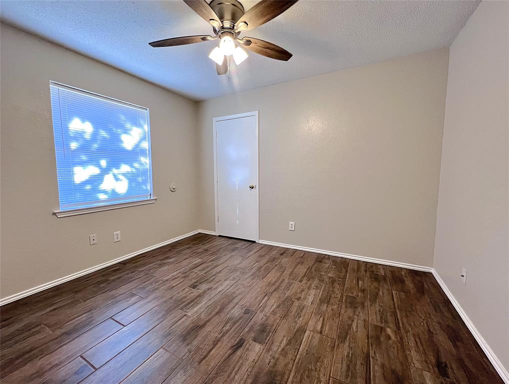 1106 Curtis Drive, Unit A Weatherford, TX 76086 - Photo 12 of 13 wooden floor in an empty room with a window