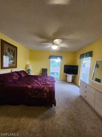 a spacious bedroom with a bed and wooden floor