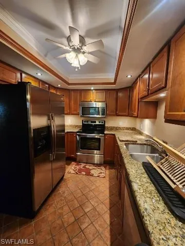 a kitchen with kitchen island granite countertop a stove top oven a sink and cabinets