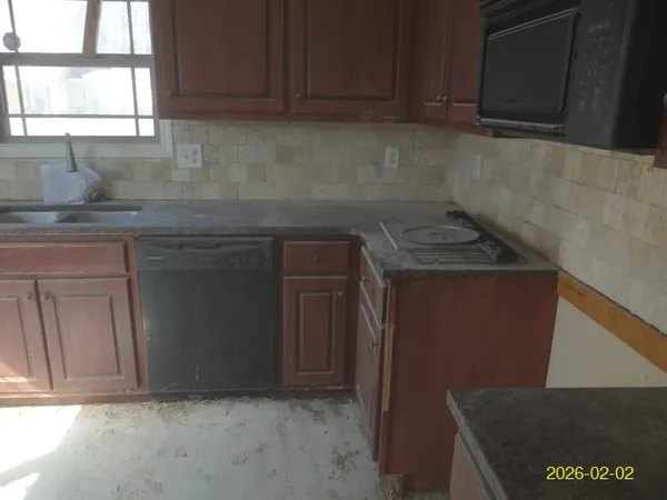 a kitchen with granite countertop a sink a stove and cabinets