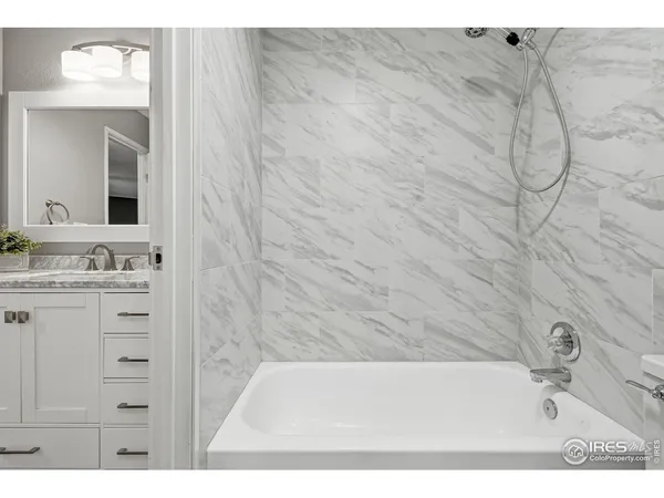 a bathroom with a sink vanity granite tub and shower
