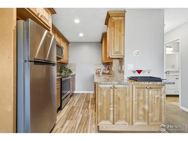 a kitchen with stainless steel appliances granite countertop a refrigerator