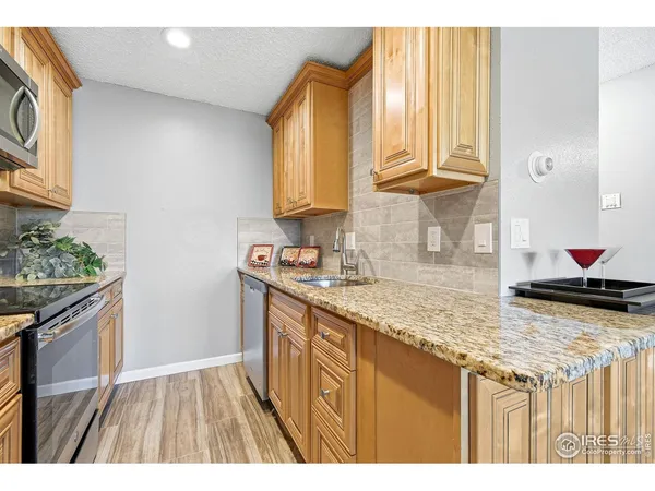 a kitchen with granite countertop a sink stainless steel appliances and cabinets