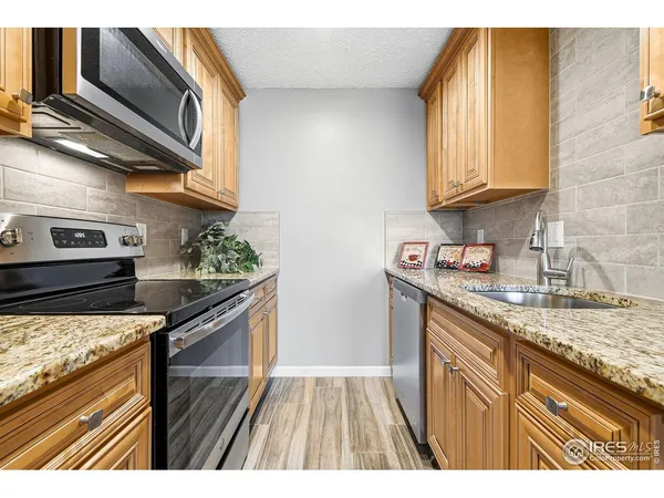 a kitchen with stainless steel appliances granite countertop a stove a sink and a microwave