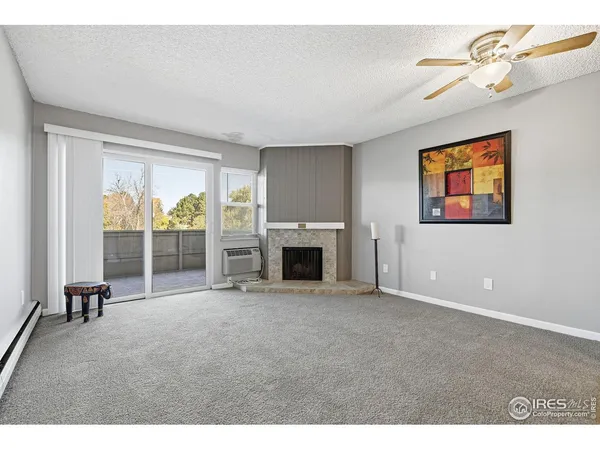 a view of an empty room with a fireplace and a window