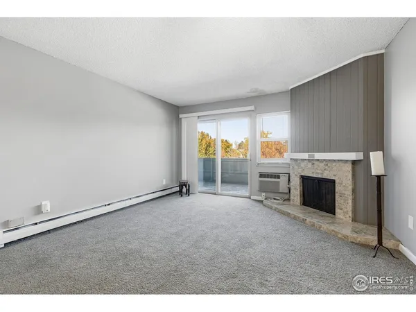 an empty room with fireplace and windows