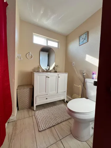 a bathroom with a toilet a sink and mirror