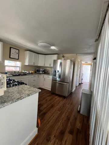 a kitchen with stainless steel appliances granite countertop a refrigerator a stove and a sink