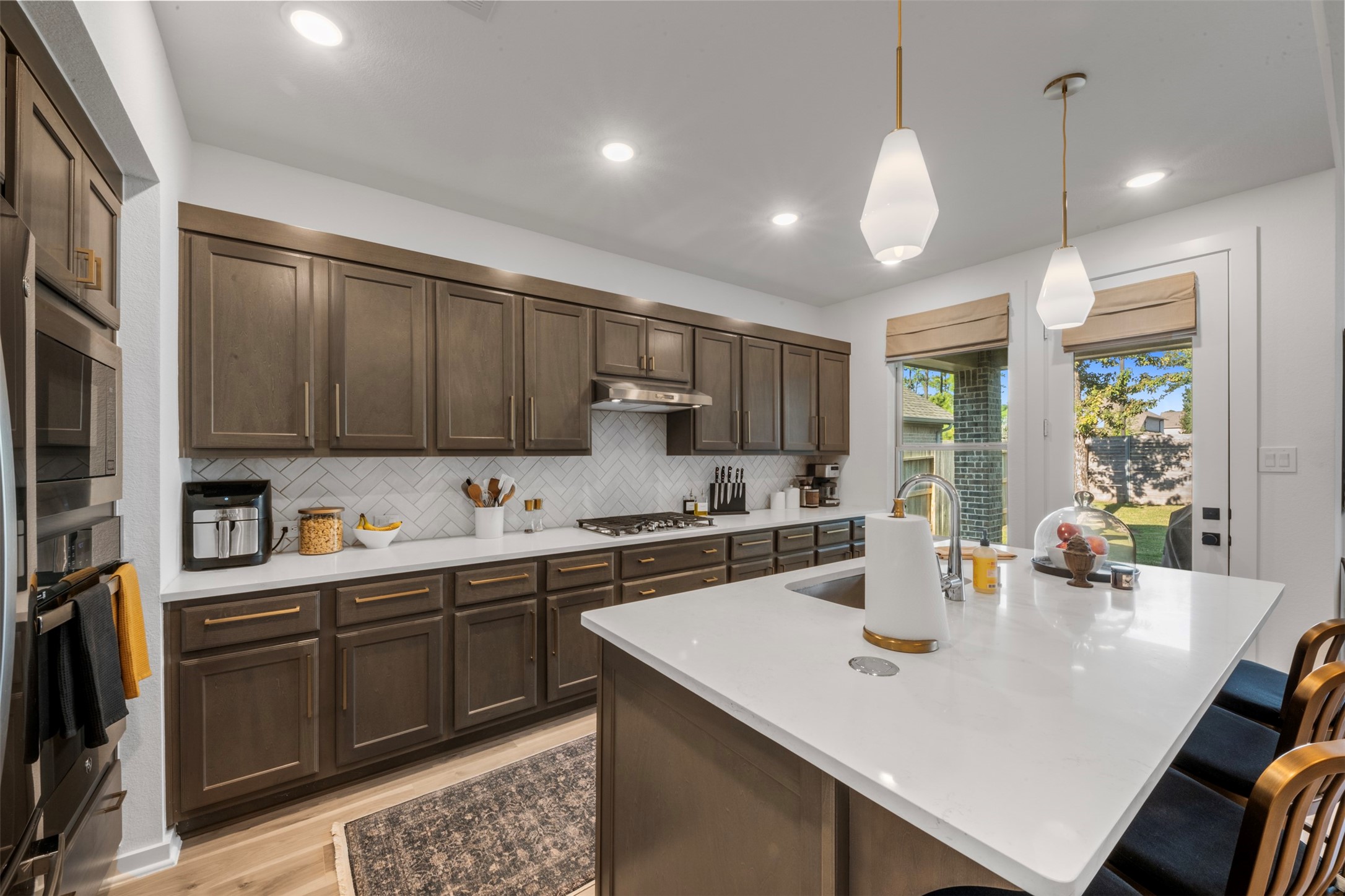 a kitchen with stainless steel appliances a sink a stove a refrigerator and cabinets