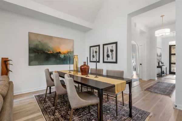 a kitchen with a dining table chairs sink and cabinets