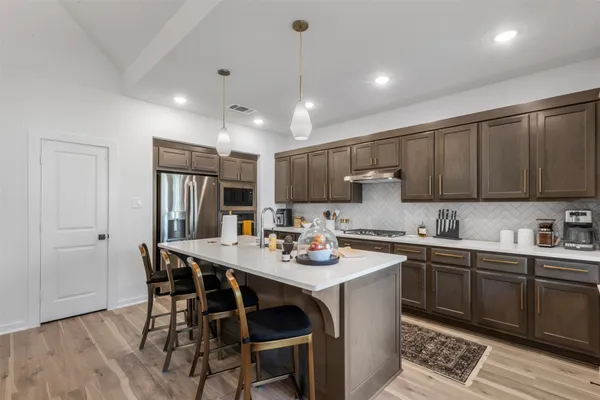 a kitchen with a sink a stove and chairs