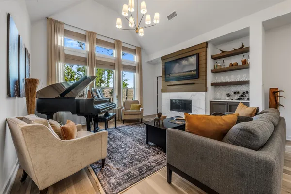 a living room with furniture a flat screen tv and a fireplace