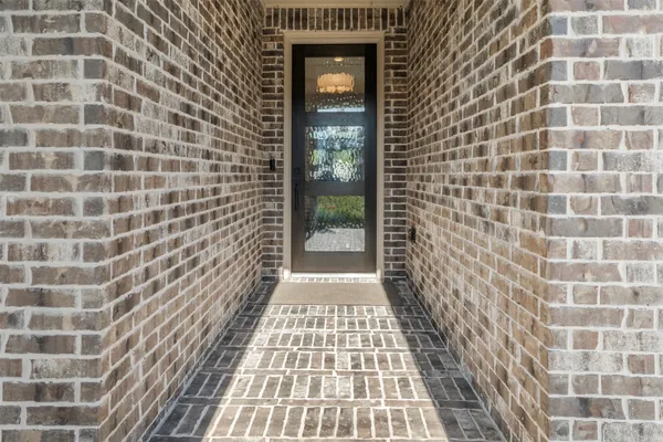 a view of a hallway with wooden floor and a chandelier