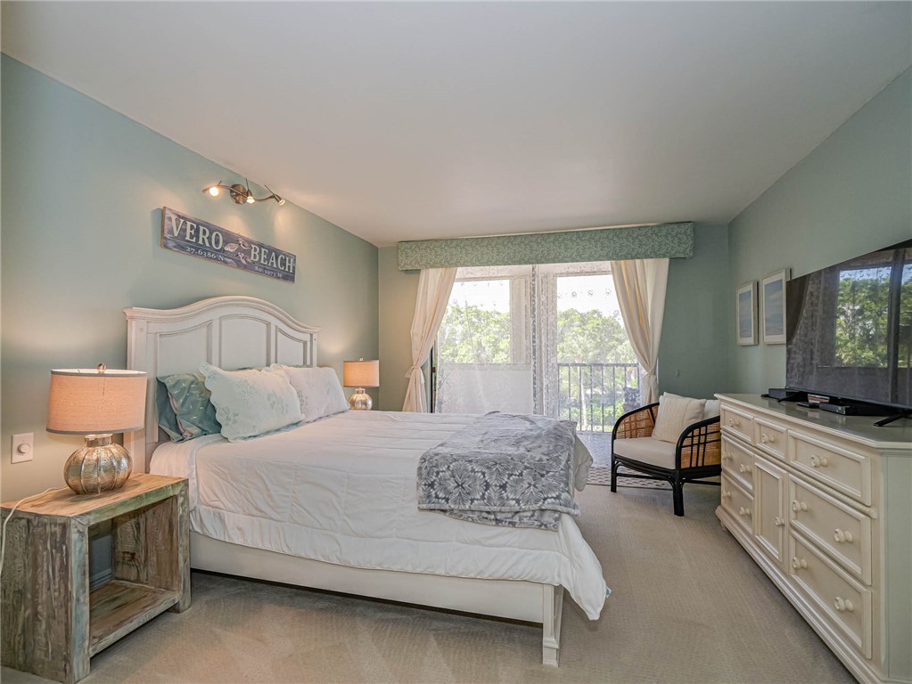 1850 Bay Road, Unit 3G Vero Beach, FL 32963 - Photo 14 of 36 a bedroom with a bed and a flat tv screen on dresser