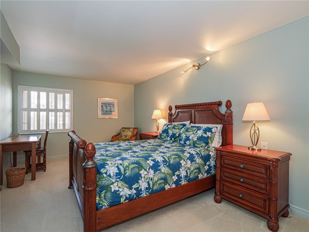1850 Bay Road, Unit 3G Vero Beach, FL 32963 - Photo 19 of 36 a bedroom with a bed and a chandelier
