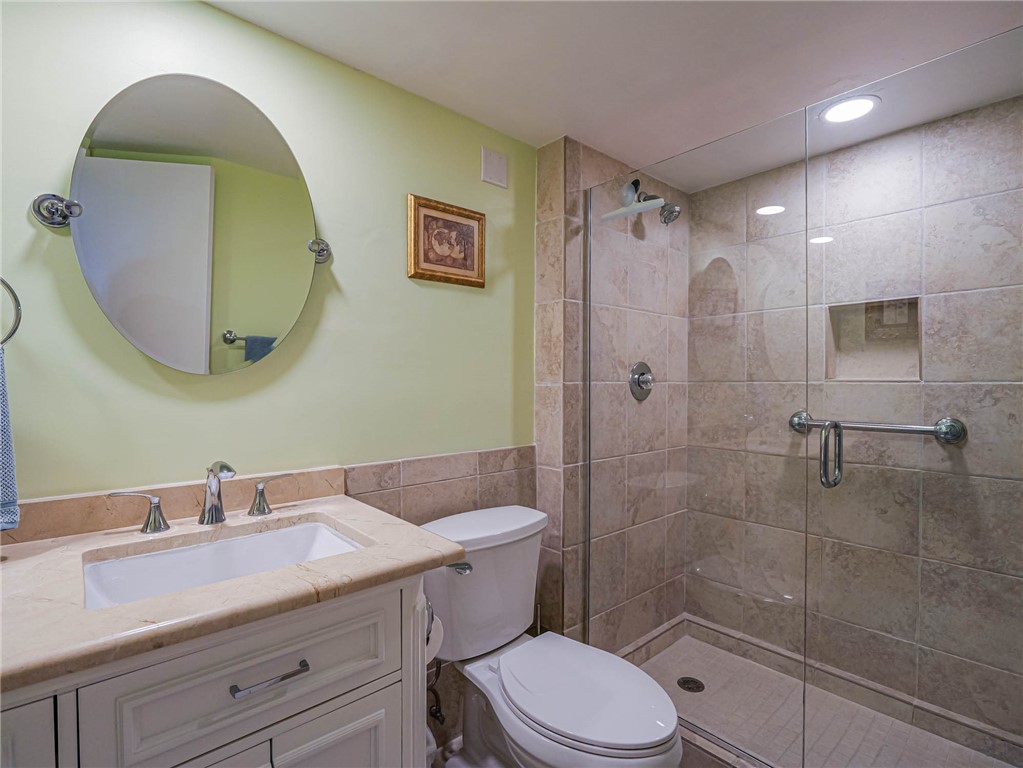 1850 Bay Road, Unit 3G Vero Beach, FL 32963 - Photo 23 of 36 a bathroom with a granite countertop toilet sink shower and mirror