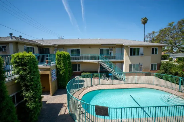 a view of a house with pool and chairs