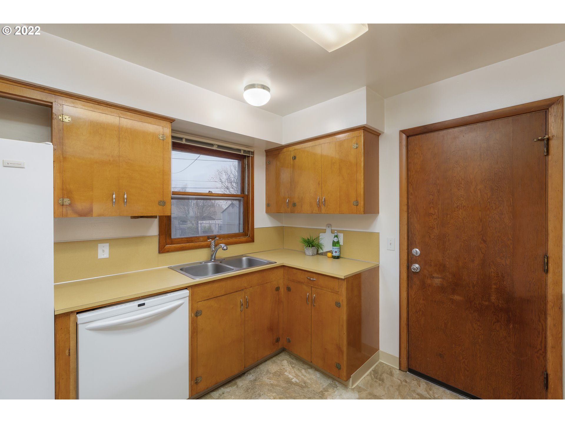 12015 Northeast Morris Street Portland, OR 97220 - Photo 11 of 23 a kitchen with a sink a refrigerator and window