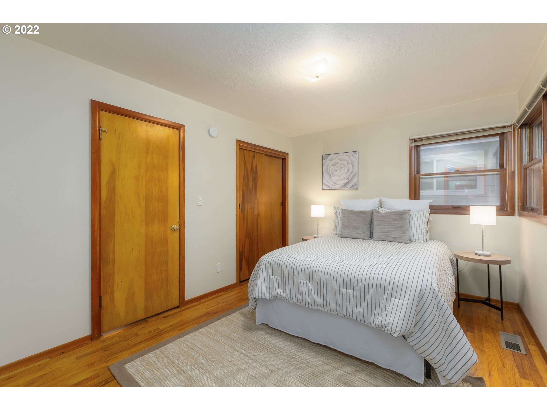 12015 Northeast Morris Street Portland, OR 97220 - Photo 13 of 23 a bedroom with a bed and wooden floor