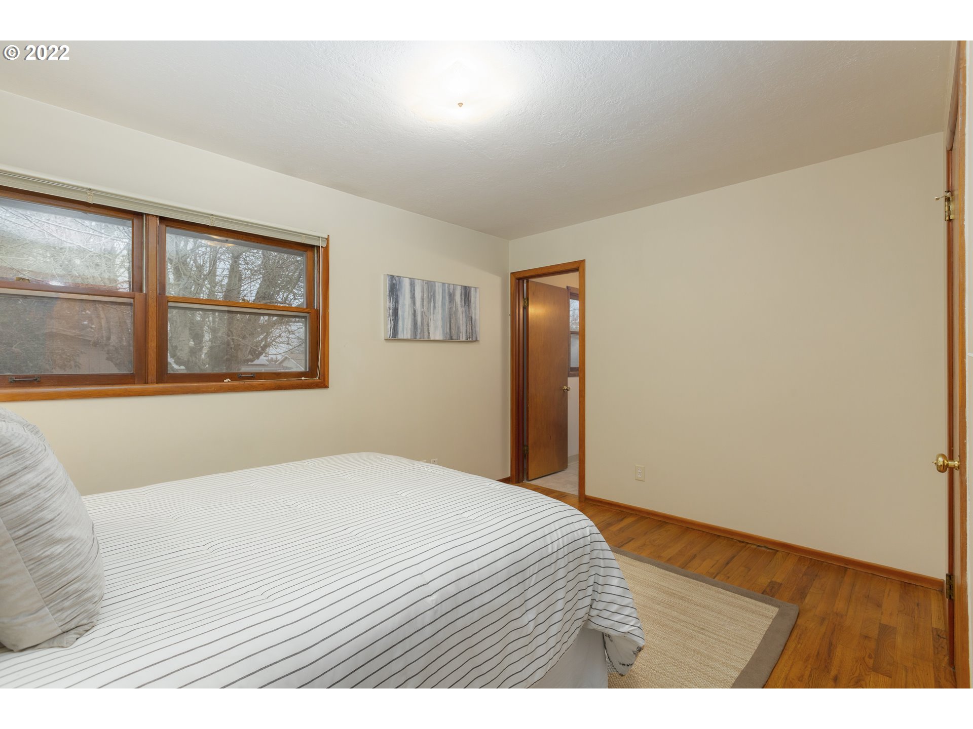 12015 Northeast Morris Street Portland, OR 97220 - Photo 15 of 23 a bedroom with a bed and a painting on the wall