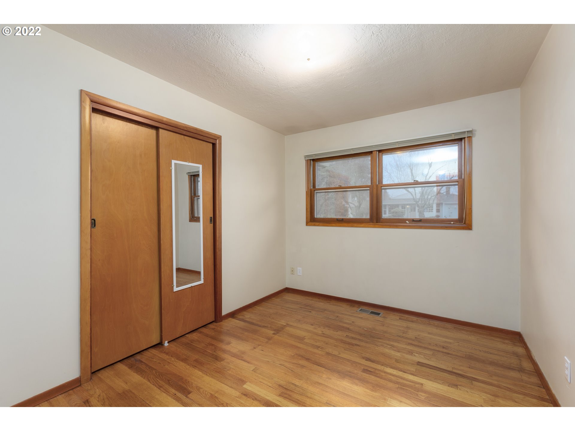 12015 Northeast Morris Street Portland, OR 97220 - Photo 17 of 23 an empty room with wooden floor and windows