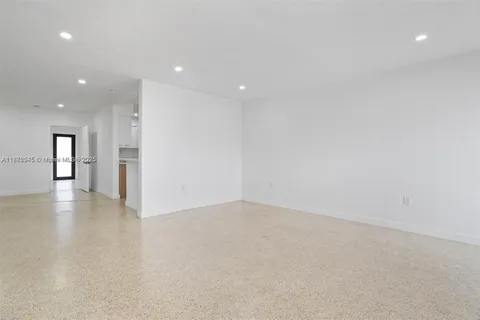 a view of an empty room with a kitchen