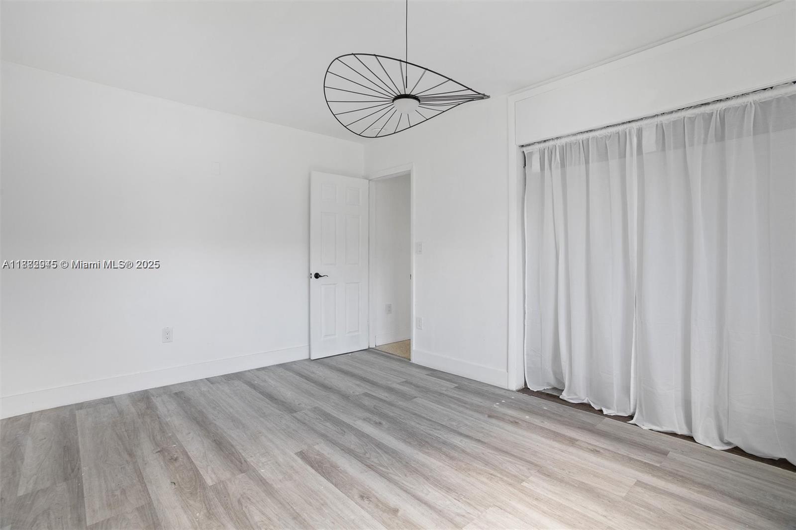70 Northeast 186th Terrace Miami, FL 33179 - Photo 23 of 32 a view of a room with wooden floor and white walls