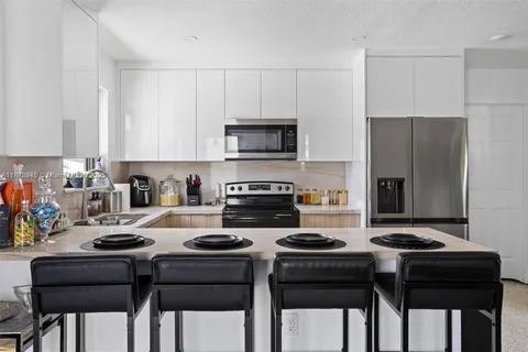 a kitchen with a stove a refrigerator and a dining table