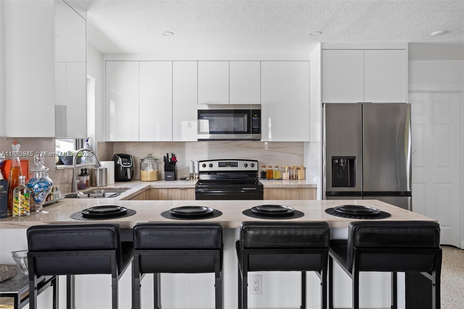 70 Northeast 186th Terrace Miami, FL 33179 - Photo 5 of 32 a kitchen with a stove a refrigerator and a dining table